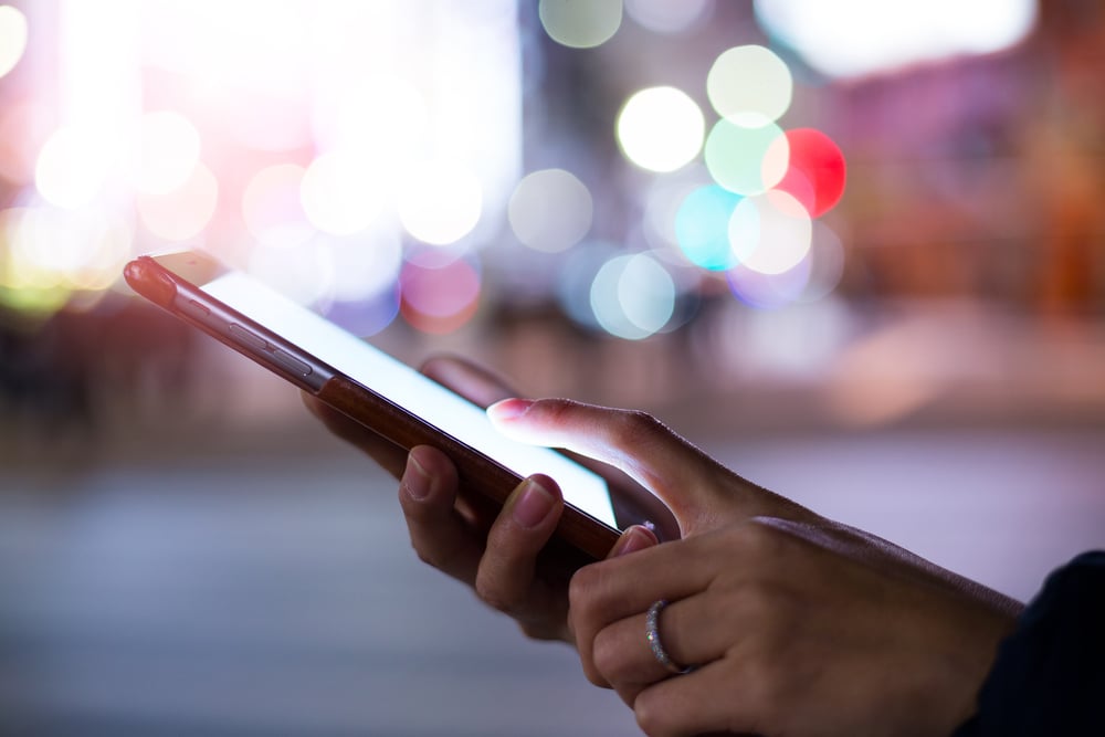 Woman using cellphone at night